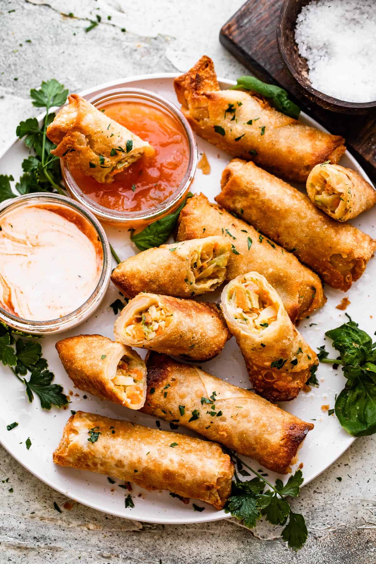 A plate of spring rolls with dipping sauce.