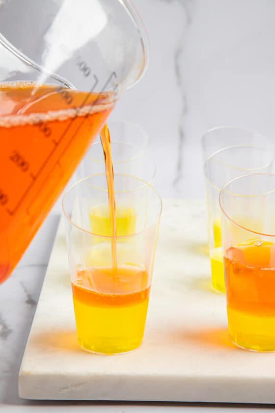 Orange jello added to shot glasses with lemon jello at the bottom.