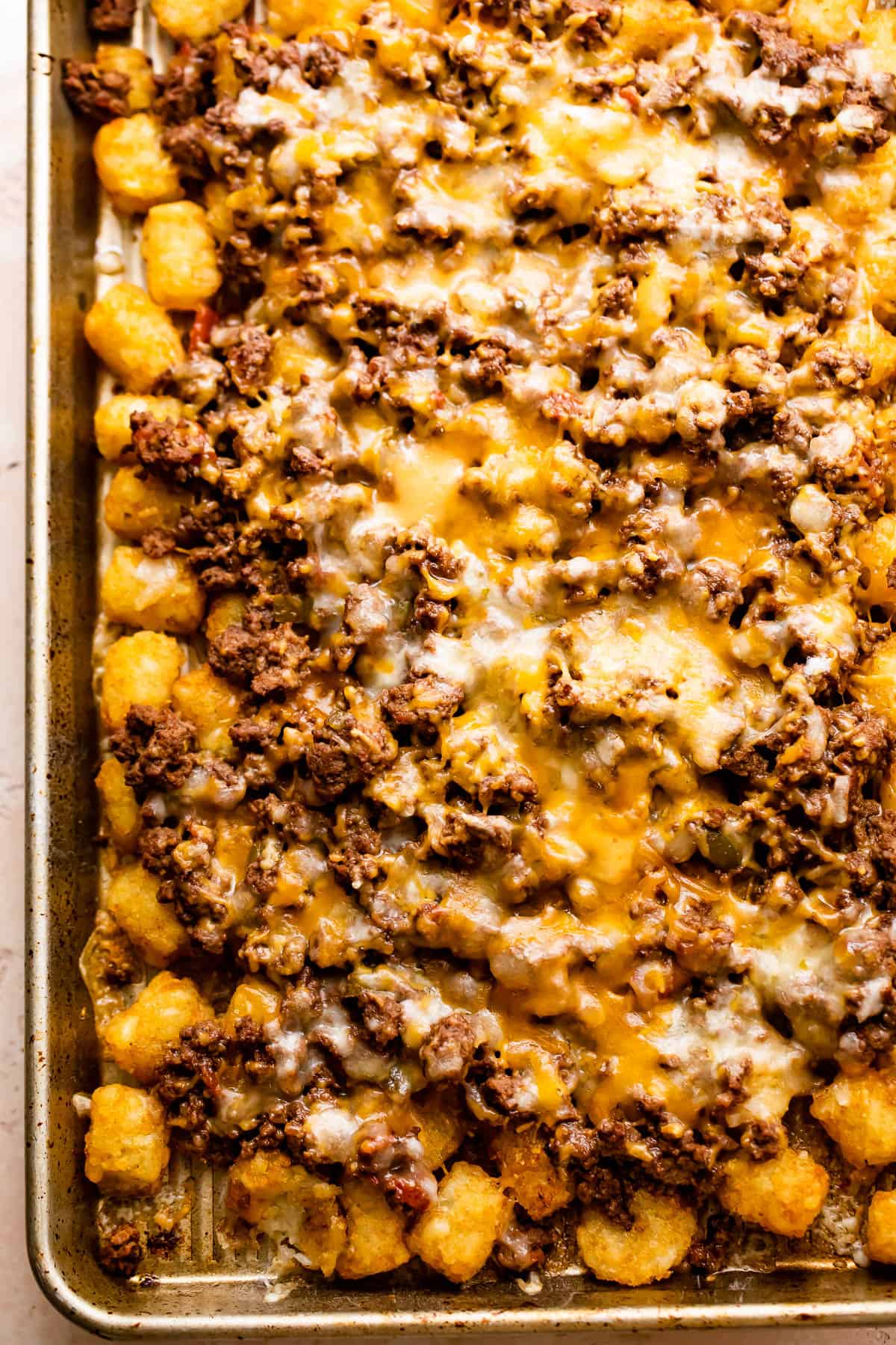 baking sheet with tater tots topped with ground beef and melted cheese