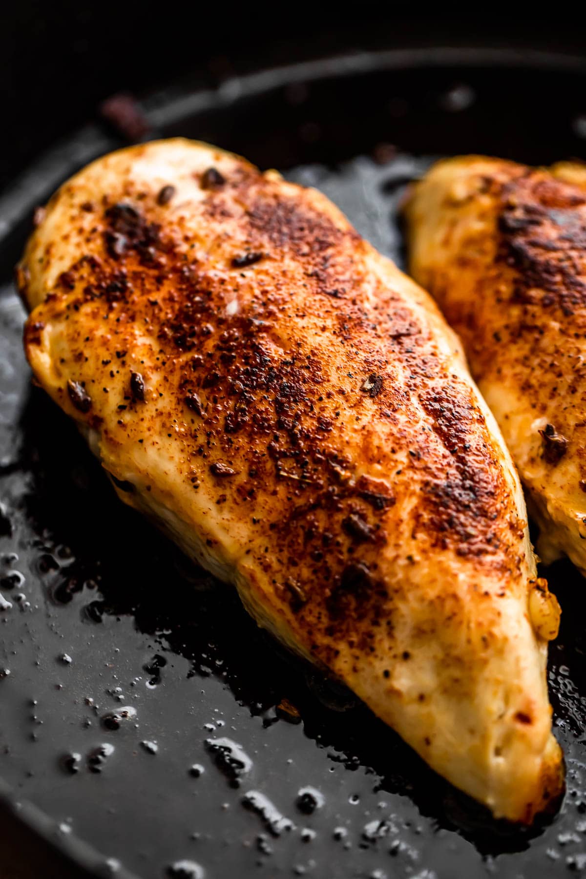 cooking chicken breasts in a cast iron skillet.