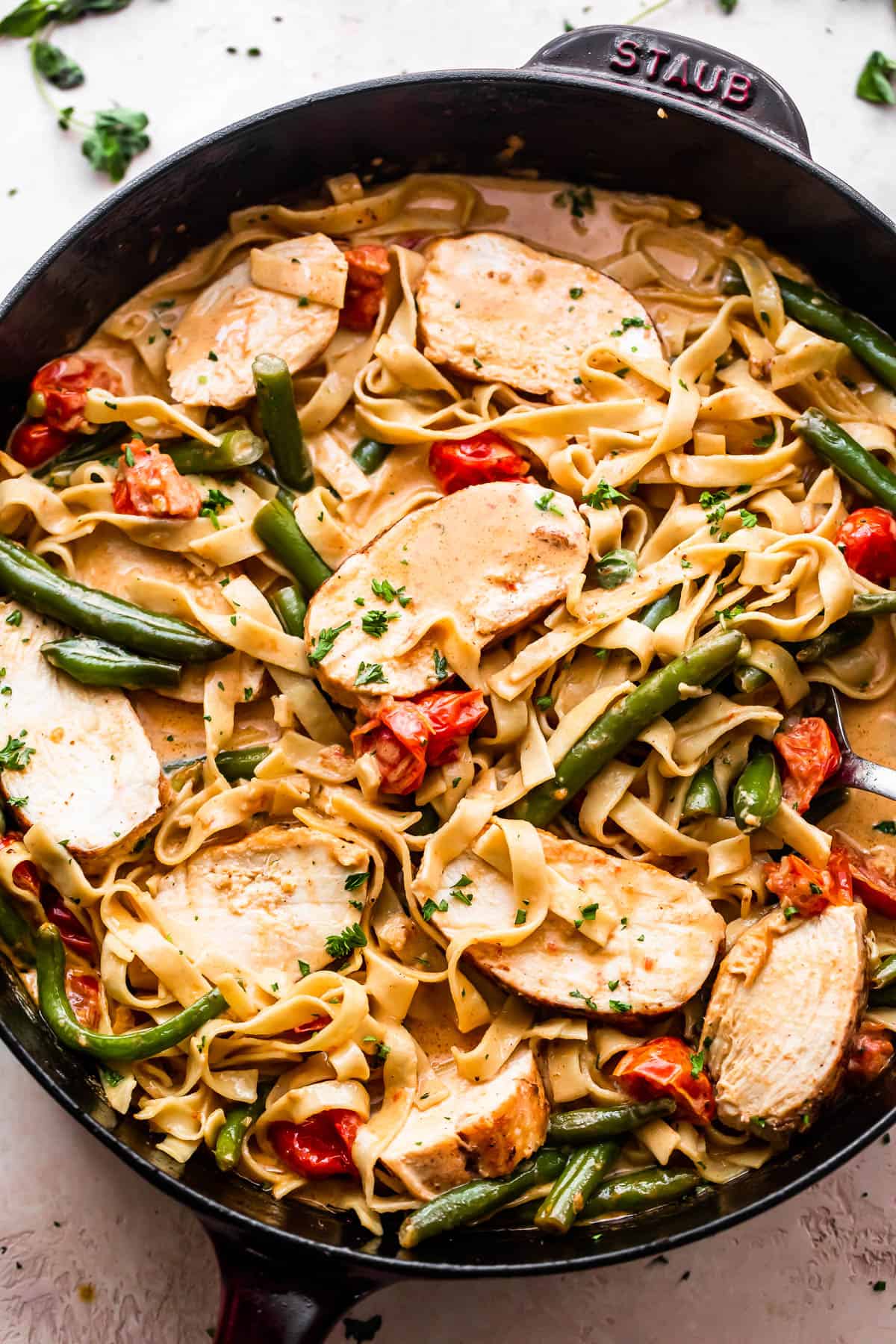 overhead shot of a skillet with Creole Blackened Chicken with Pasta, tomatoes, and green beans