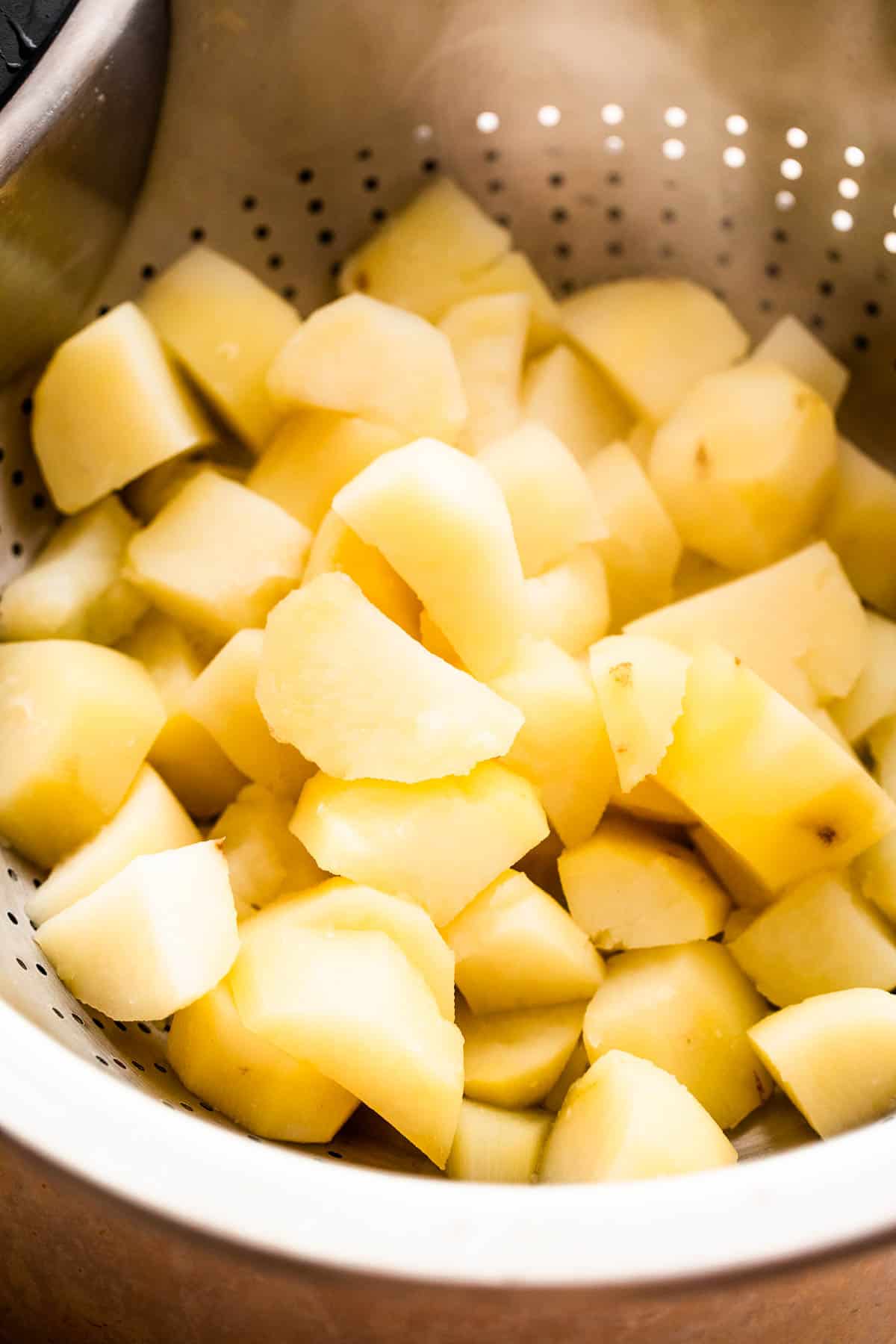 cooked diced potatoes in a collander