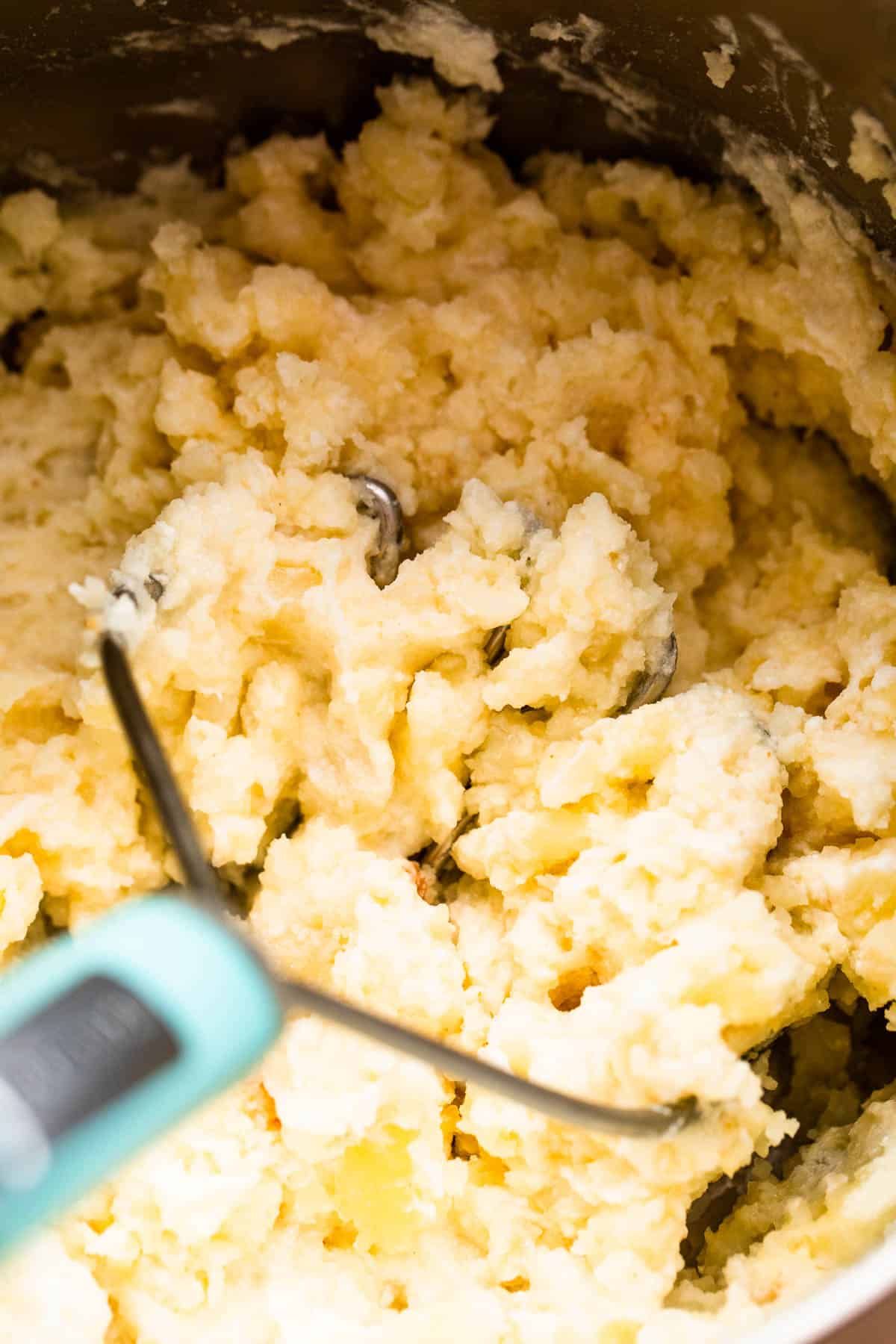 mashing potatoes with a potato masher