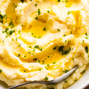 close up overhead shot of creamy mashed potatoes garnished with melted butter and parsley