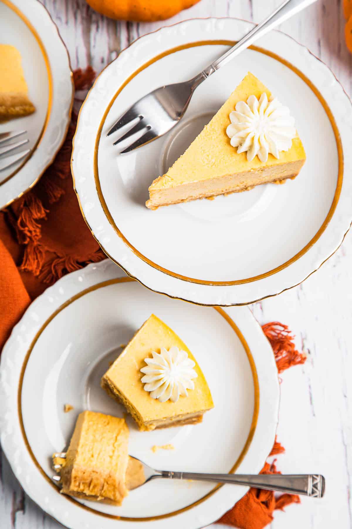 overhead shot of two plates with slices of pumpkin cheesecake