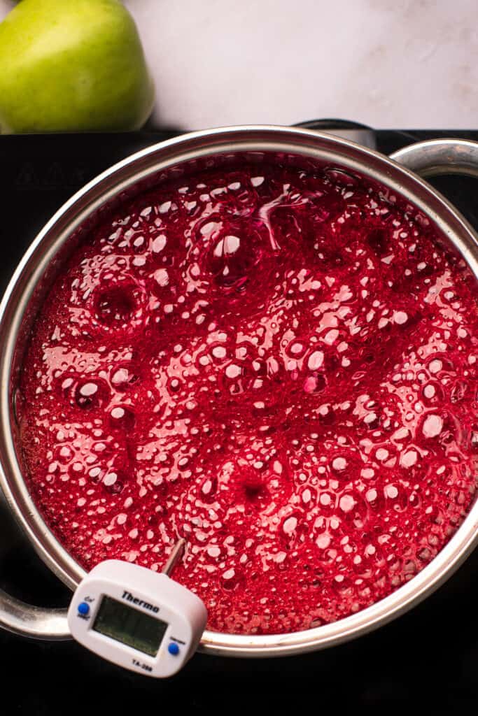 A saucepan of boiling sugar candy mixture that has been dyed red.