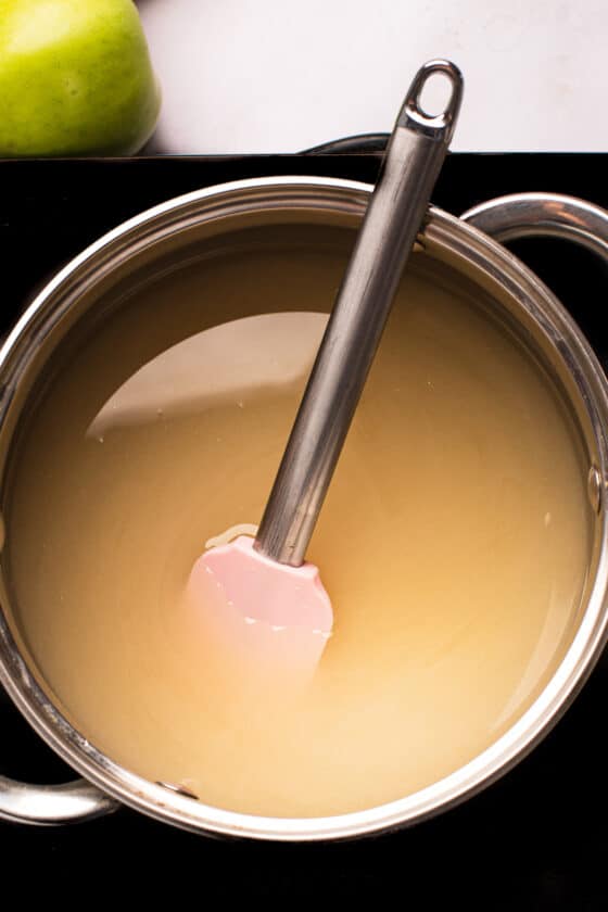 A saucepan of undyed sugar candy mixture with a spatula resting in it.