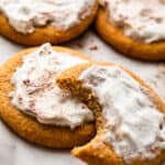 five frosted pumpkin cookies set on a white background