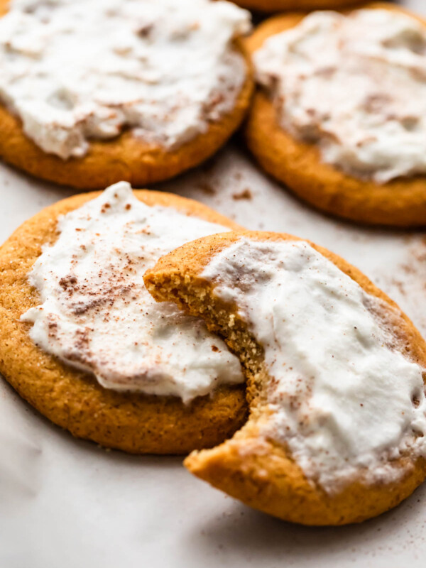 five frosted pumpkin cookies set on a white background