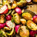 Close up shot of halved Roasted Brussels Sprouts and Radishes on a baking sheet