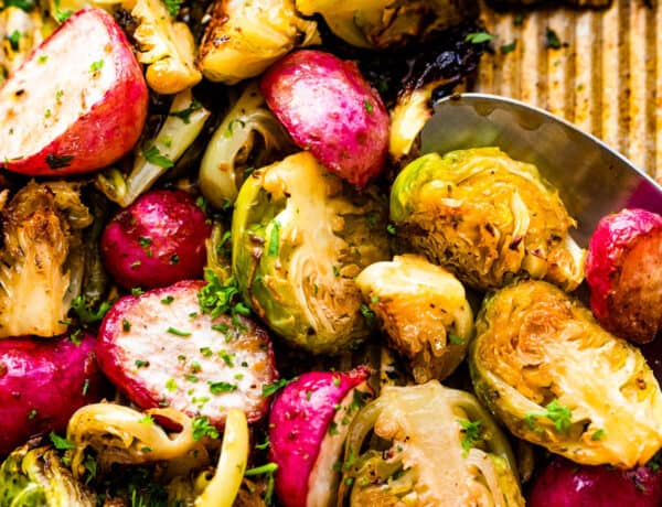 Close up shot of halved Roasted Brussels Sprouts and Radishes on a baking sheet