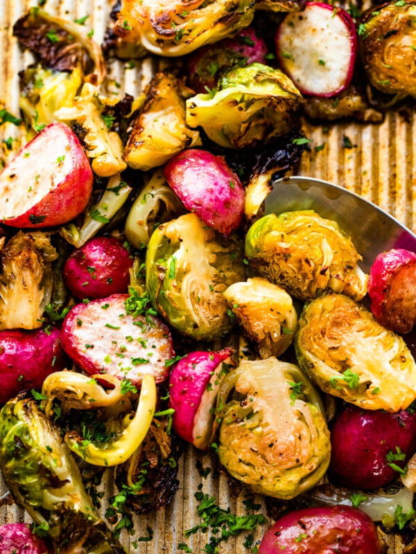 Close up shot of halved Roasted Brussels Sprouts and Radishes on a baking sheet
