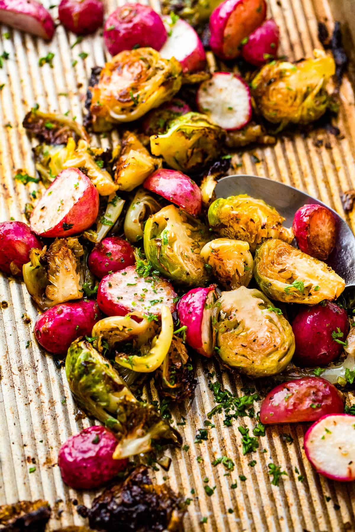 overhead shot of halved Roasted Brussels Sprouts and Radishes on a baking sheet