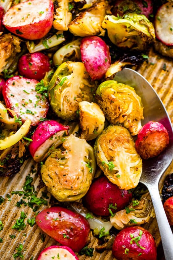 halved Roasted Brussels Sprouts and Radishes on a baking sheet