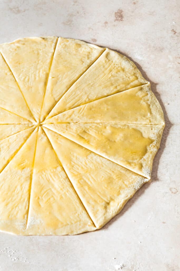Dough rolled into a circle and cut into wedges, brushed with butter.