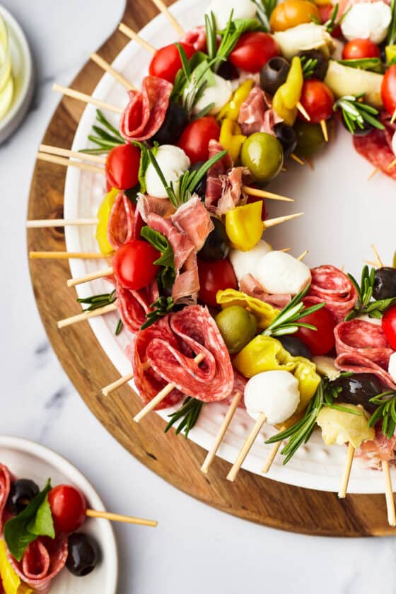 Close-up shot of an antipasto wreath with skewers of prosciutto, pepperoncini, grape tomatoes, etc.