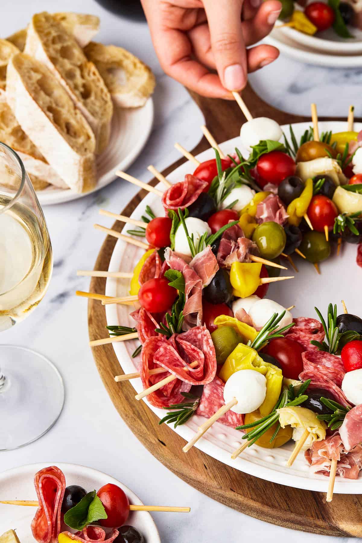 An antipasto wreath with a portion of the individual skewers on a small plate.
