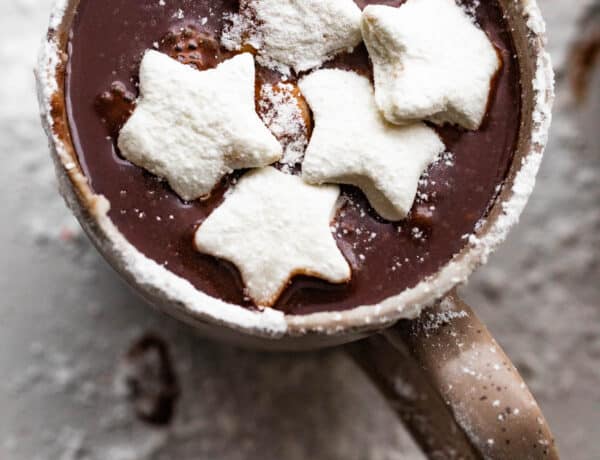 overhead shot of hot chocolate in a brown mug and topped with star shaped marshmallows