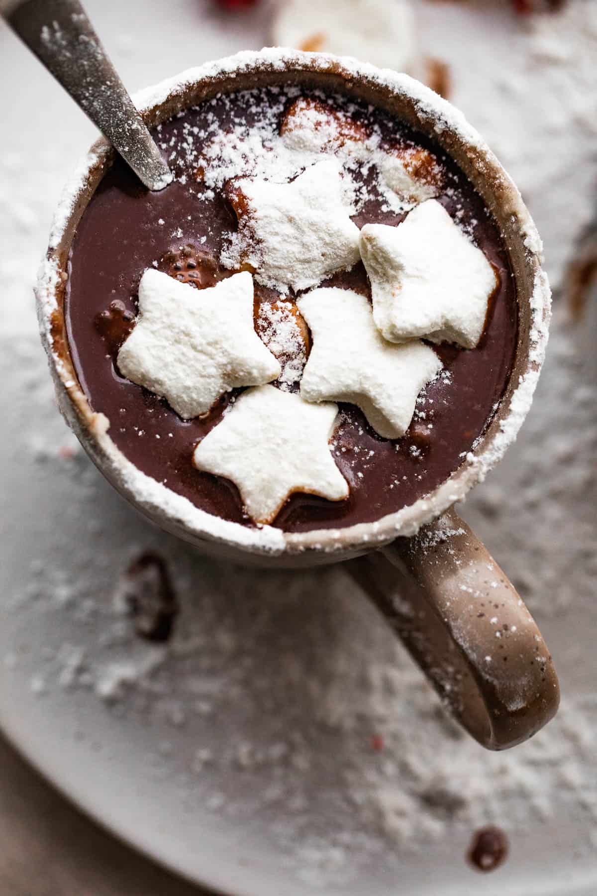 overhead shot of hot chocolate in a brown mug and topped with star shaped marshmallows