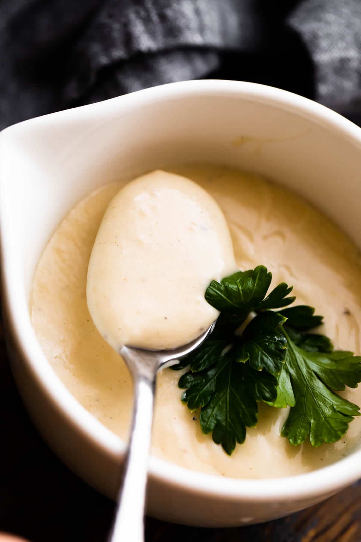 overhead shot of a white ceramic cup filled with homemade cream of chicken soup