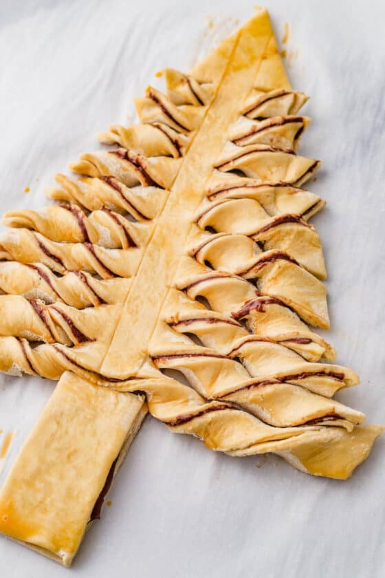The unbaked puff pastry tree, with the horizontal strips twisted to show the filling.