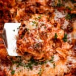 up close shot of a spatula lifting up a piece of lasagna from the slow cooker.