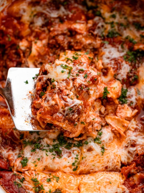 up close shot of a spatula lifting up a piece of lasagna from the slow cooker.
