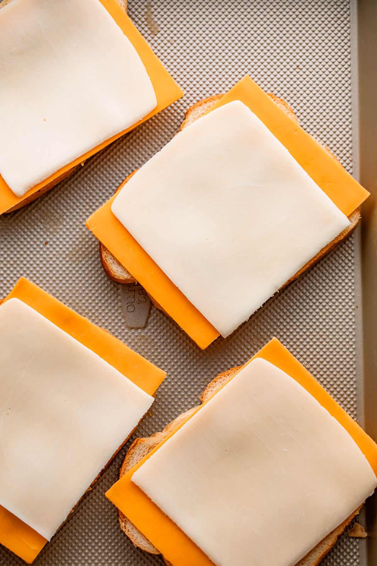 cheese slices set on top of four bread slices.