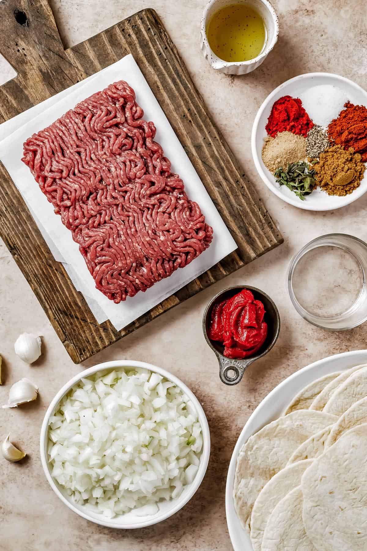 From top left: Ground beef, oil, spices, water, tomato paste, chopped onions, tortillas.