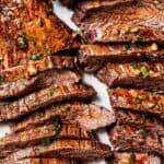 Sliced cooked steak on a cutting board.