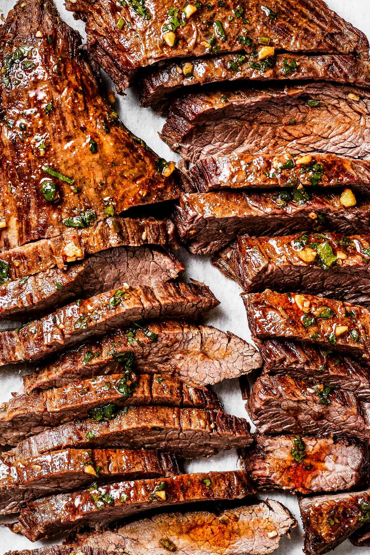 Sliced cooked steak on a cutting board.