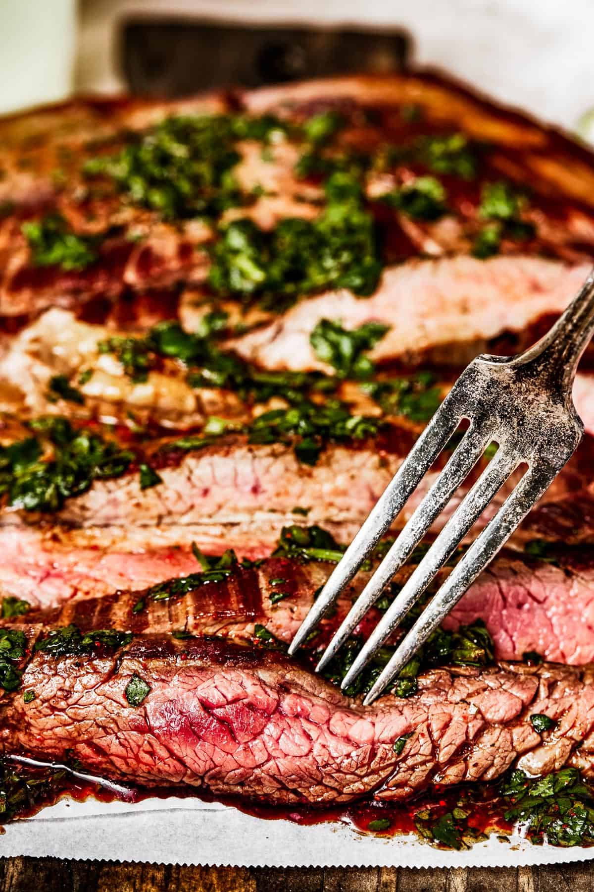 Side view of sliced flank steak with a fork.