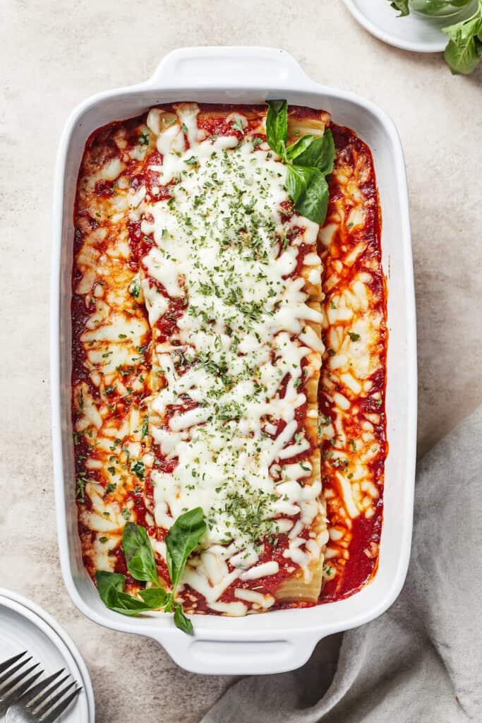 A baked pasta dish topped with cheese and garnished with herbs.
