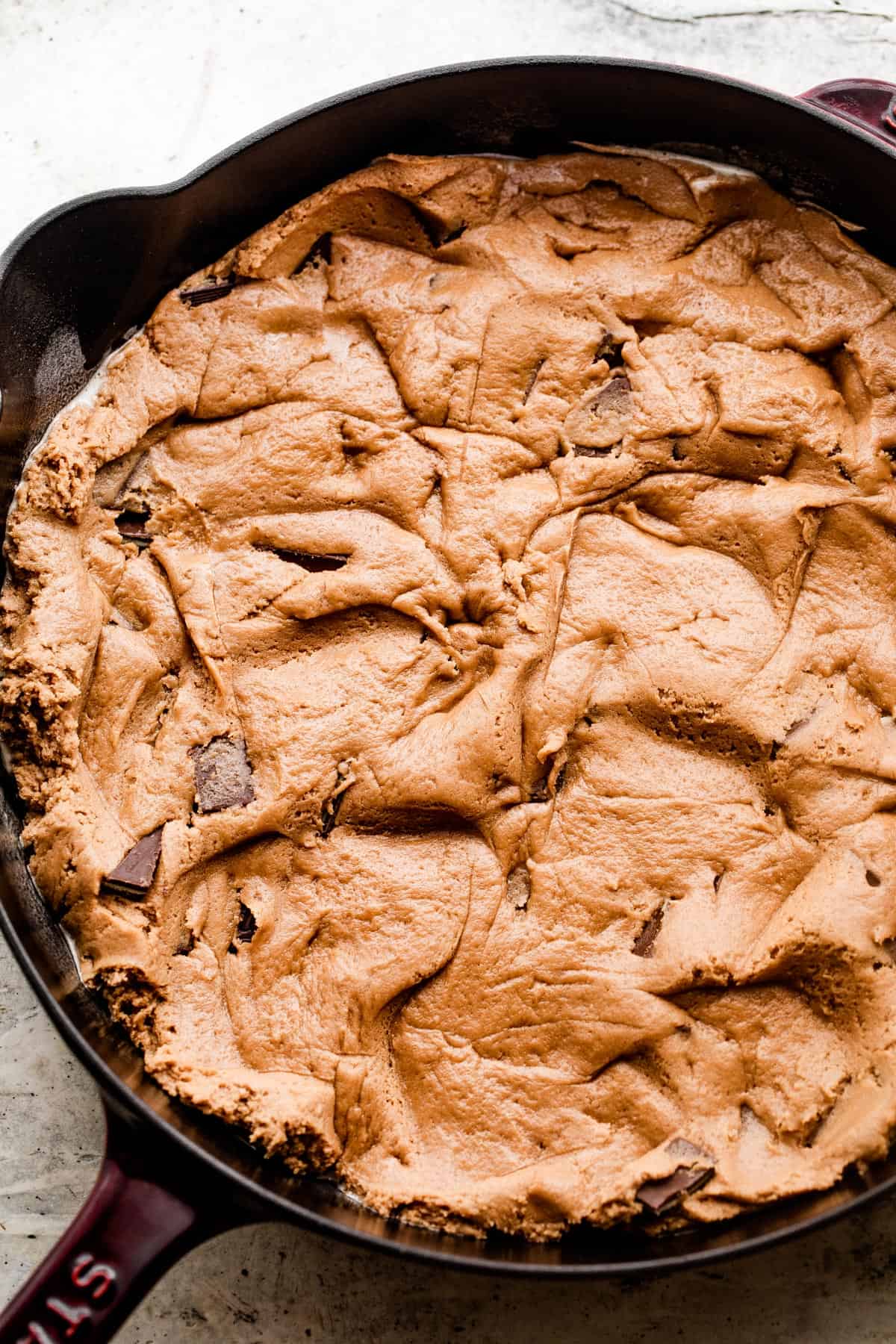 raw cookie dough spread out into a skillet.