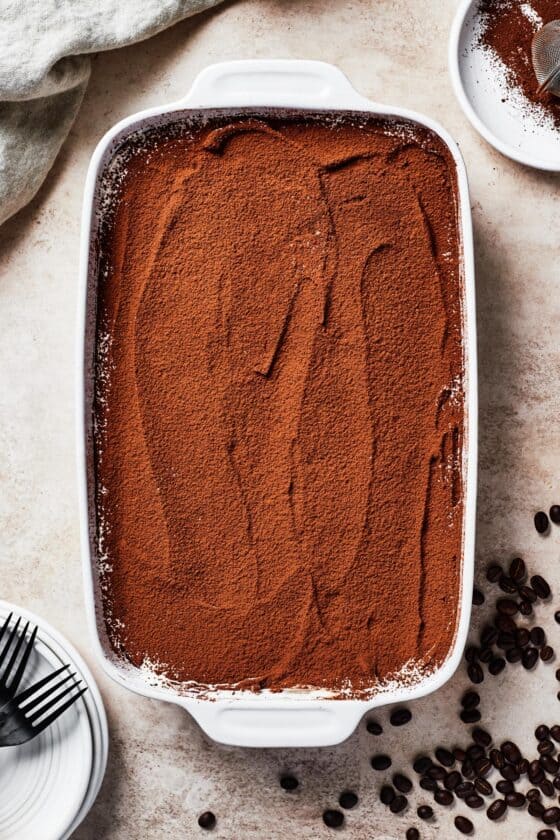 A baking dish with a cocoa-powder topped dessert.