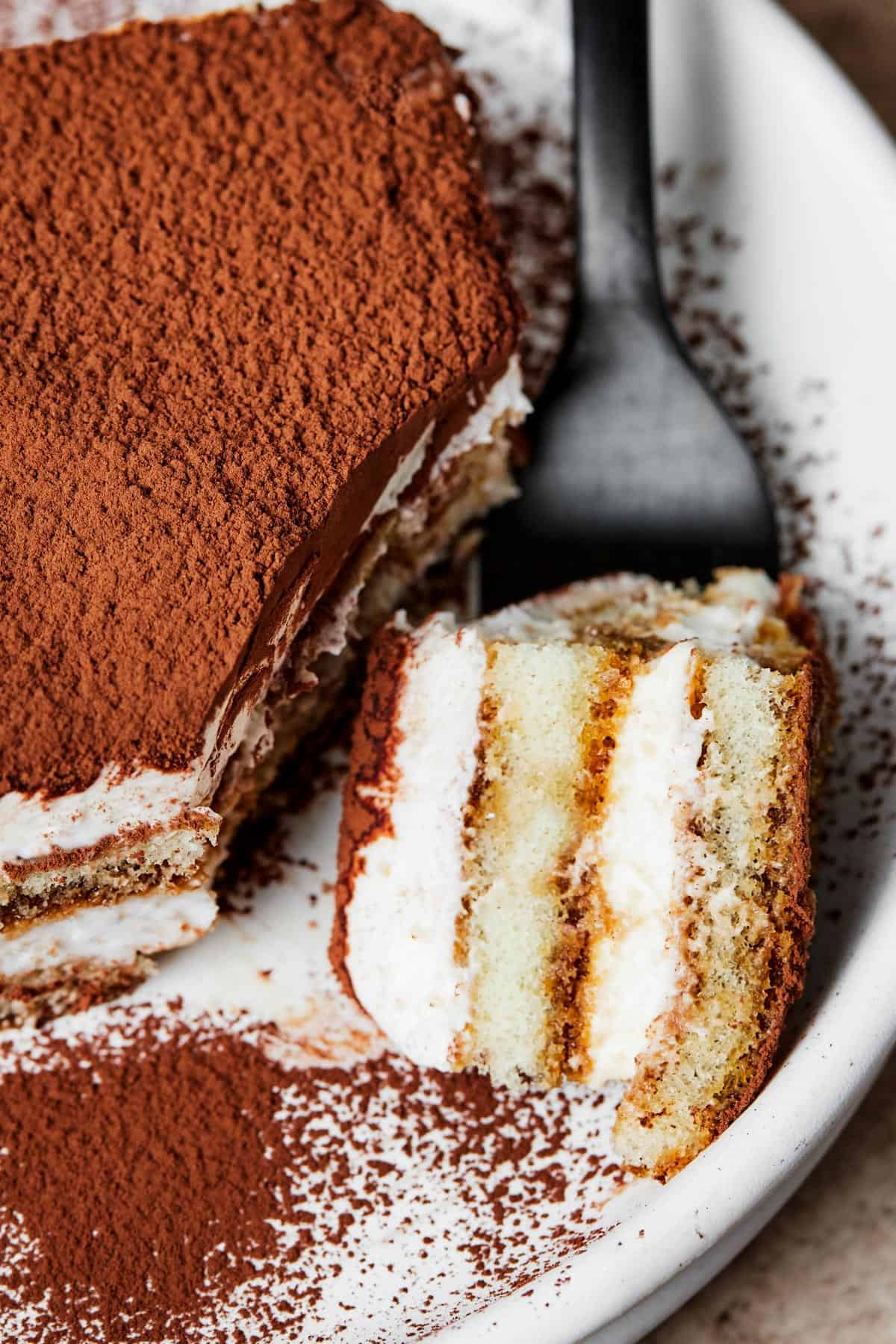 Close-up overhead shot of a serving of layered dessert. A bite-sized piece is on the fork, lying on the plate.