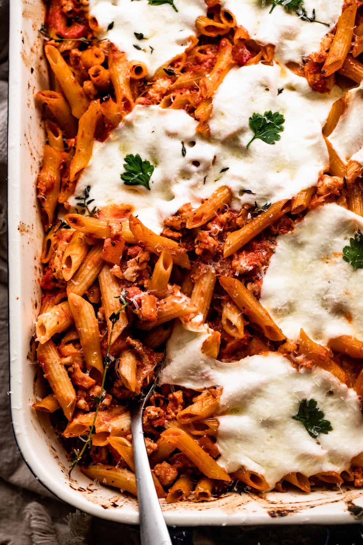 overhead shot of a baking dish with Baked Penne Alla Vodka topped with melted mozzarella cheese.