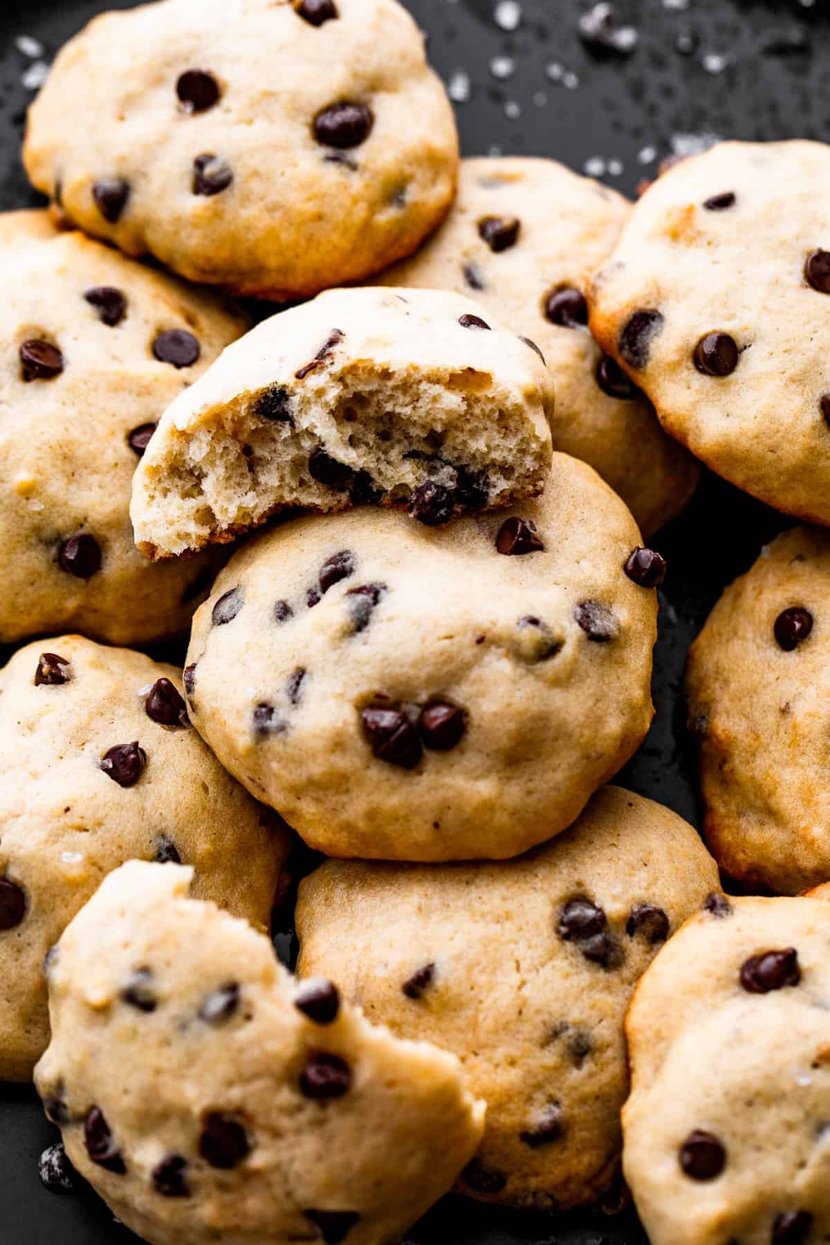 overhead up close shot of banana chocolate chips cookies served on a black plate.
