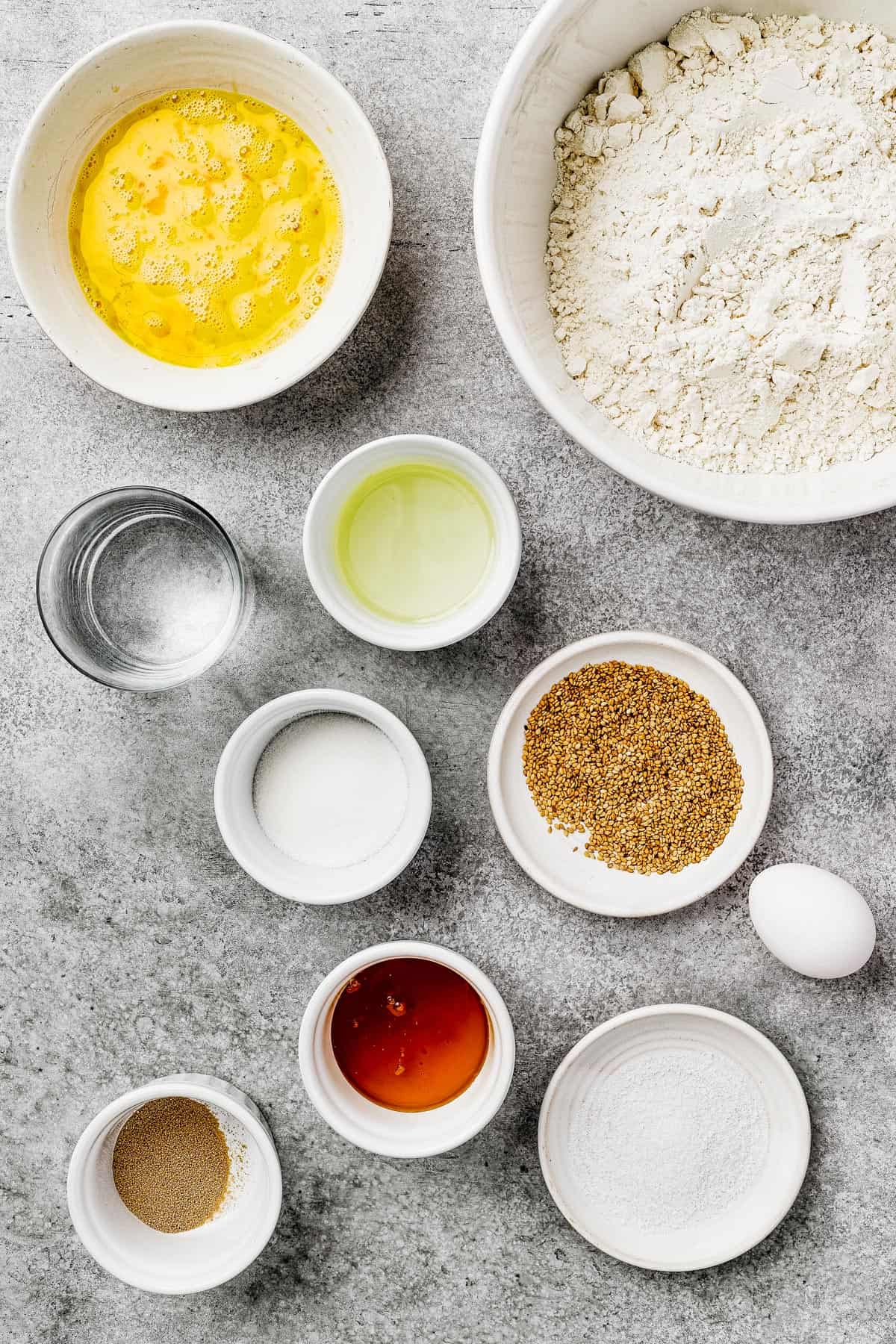 From top left: Beaten eggs, flour, water, oil, sugar, sesame seeds, yeast, honey, salt.