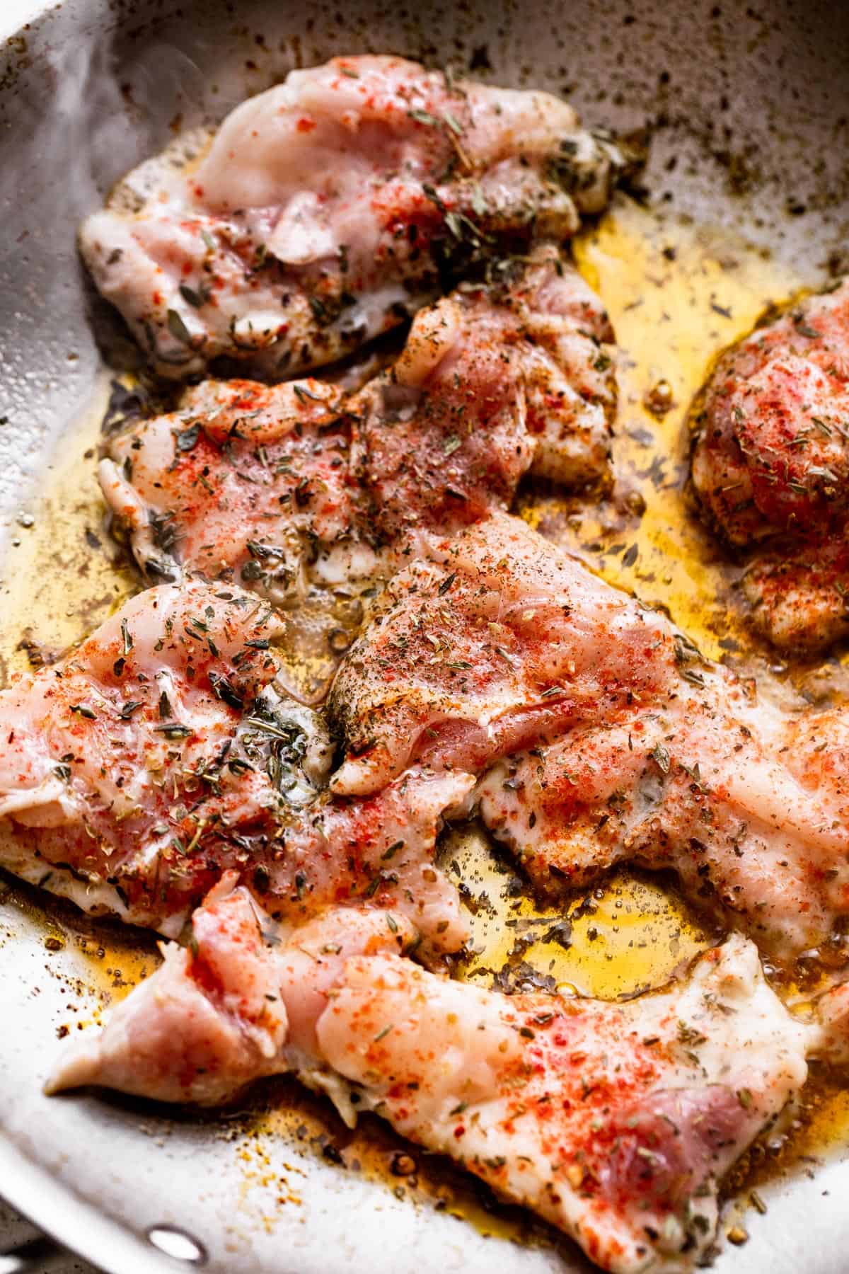 cooking boneless chicken thighs in a skillet.