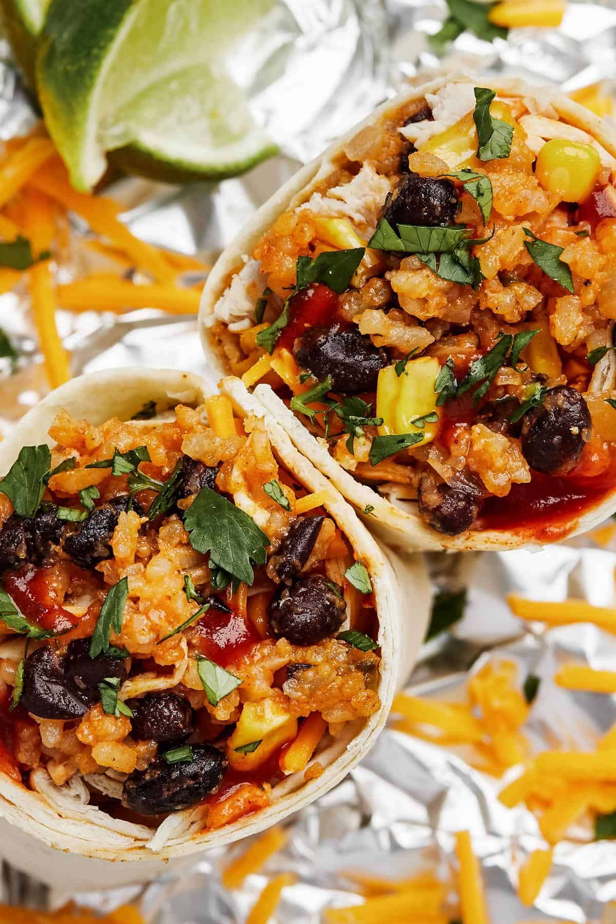 Close-up shot of two burrito halves, garnished with chopped herbs.