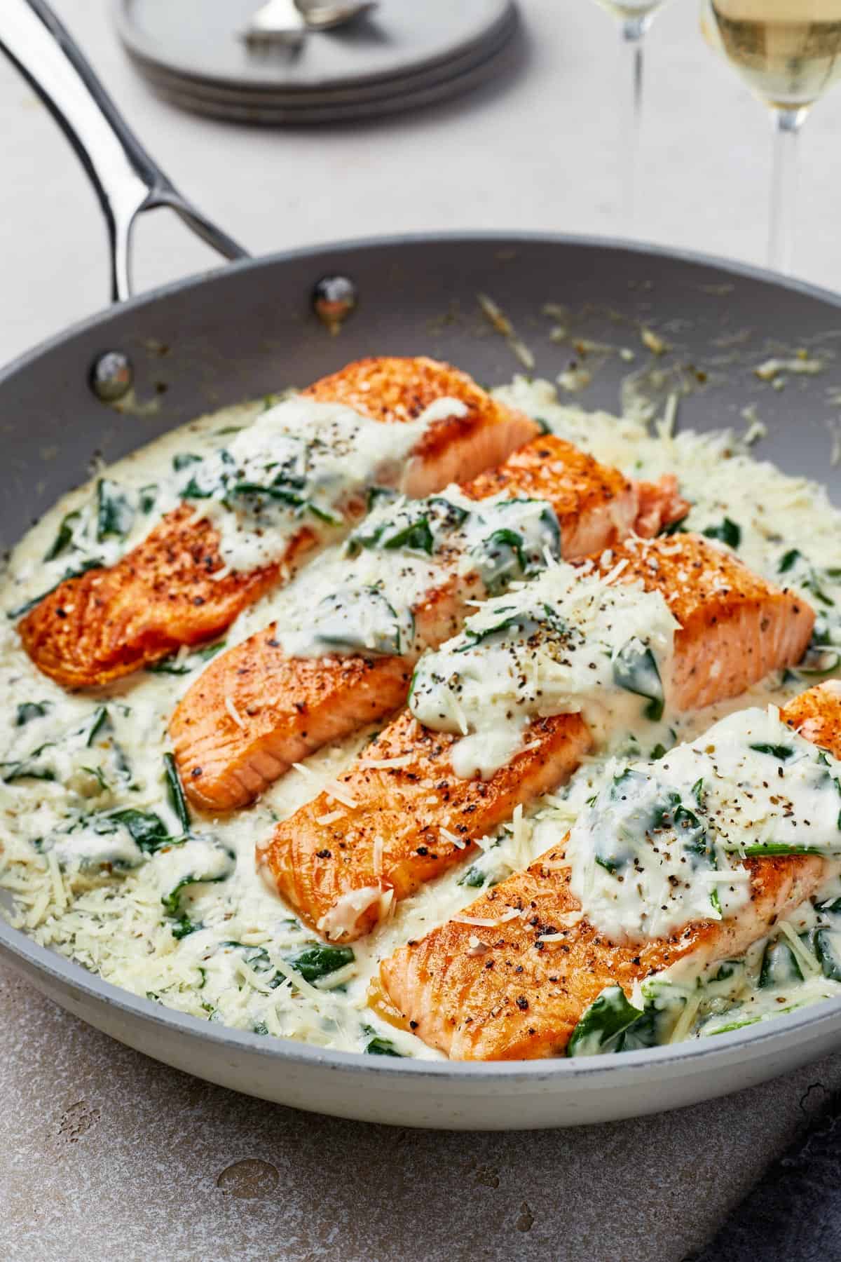 Close-up shot of pan-fried salmon in Florentine sauce.