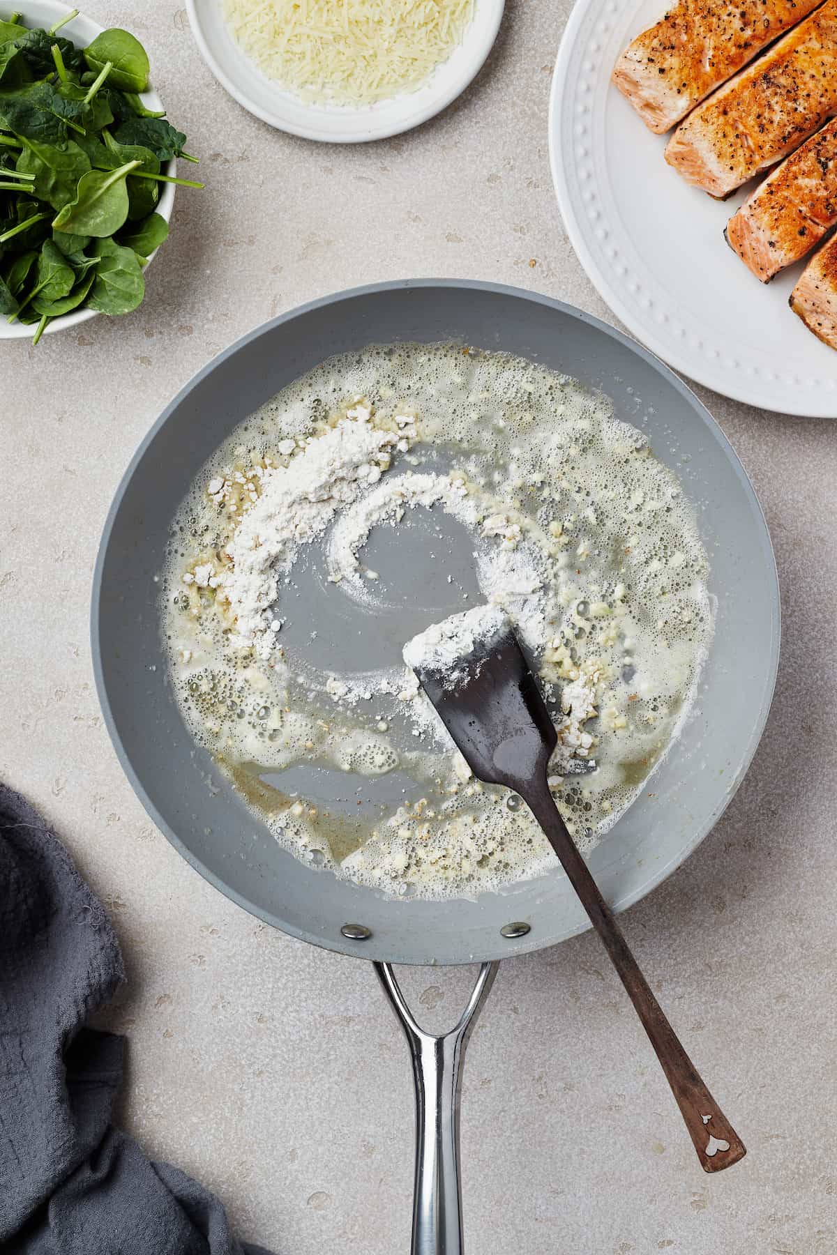 A skillet with melted butter, garlic, and flour cooking in it.