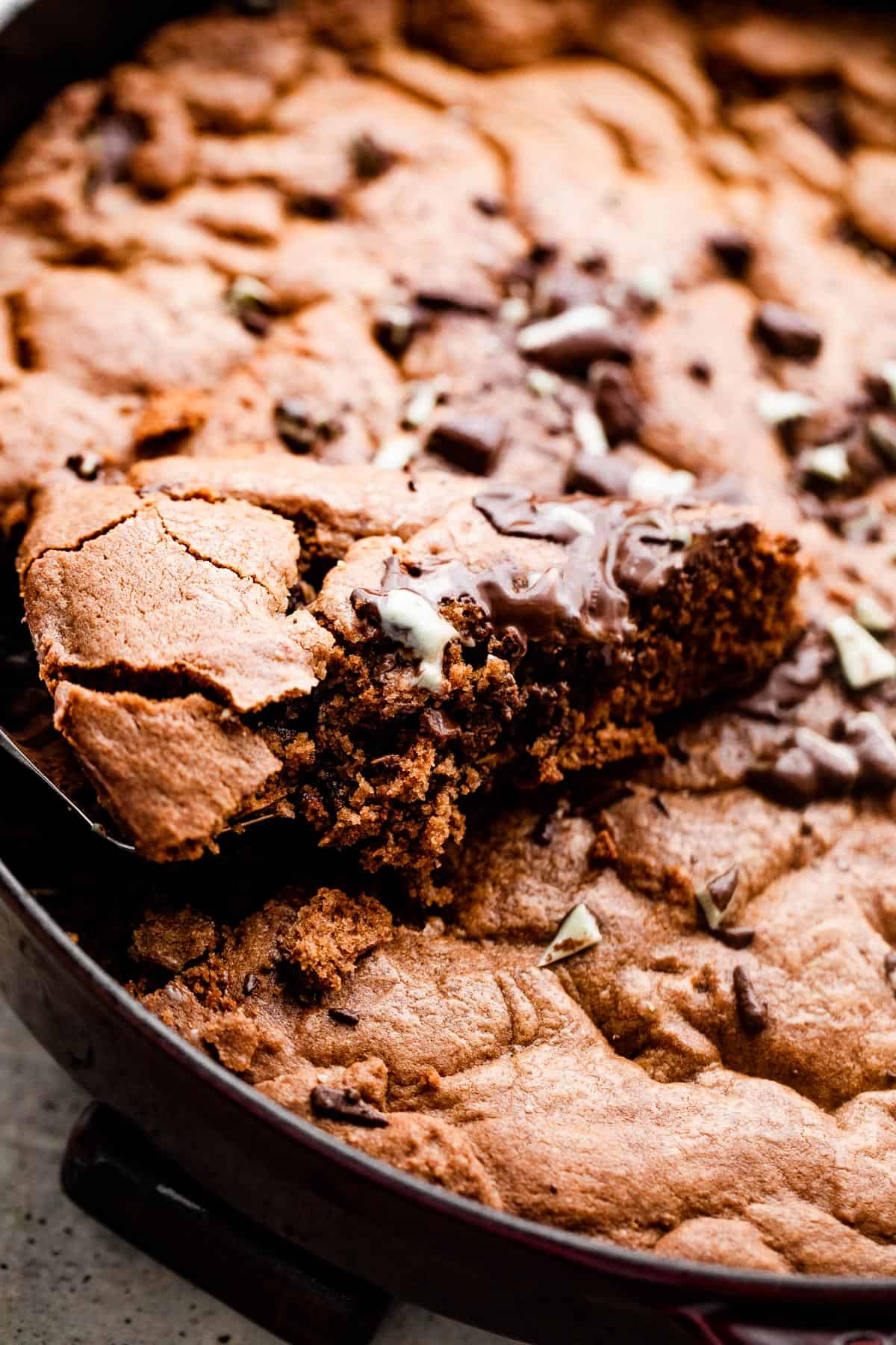 pulling out a wedge of a cookie from a skillet