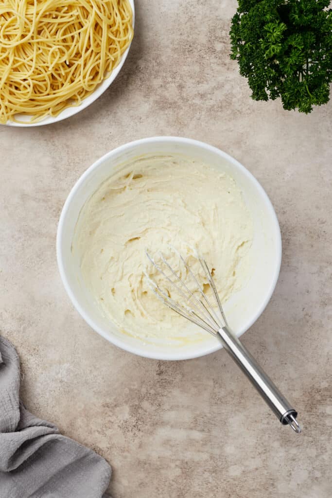 Ricotta and egg whisked together in a mixing bowl.