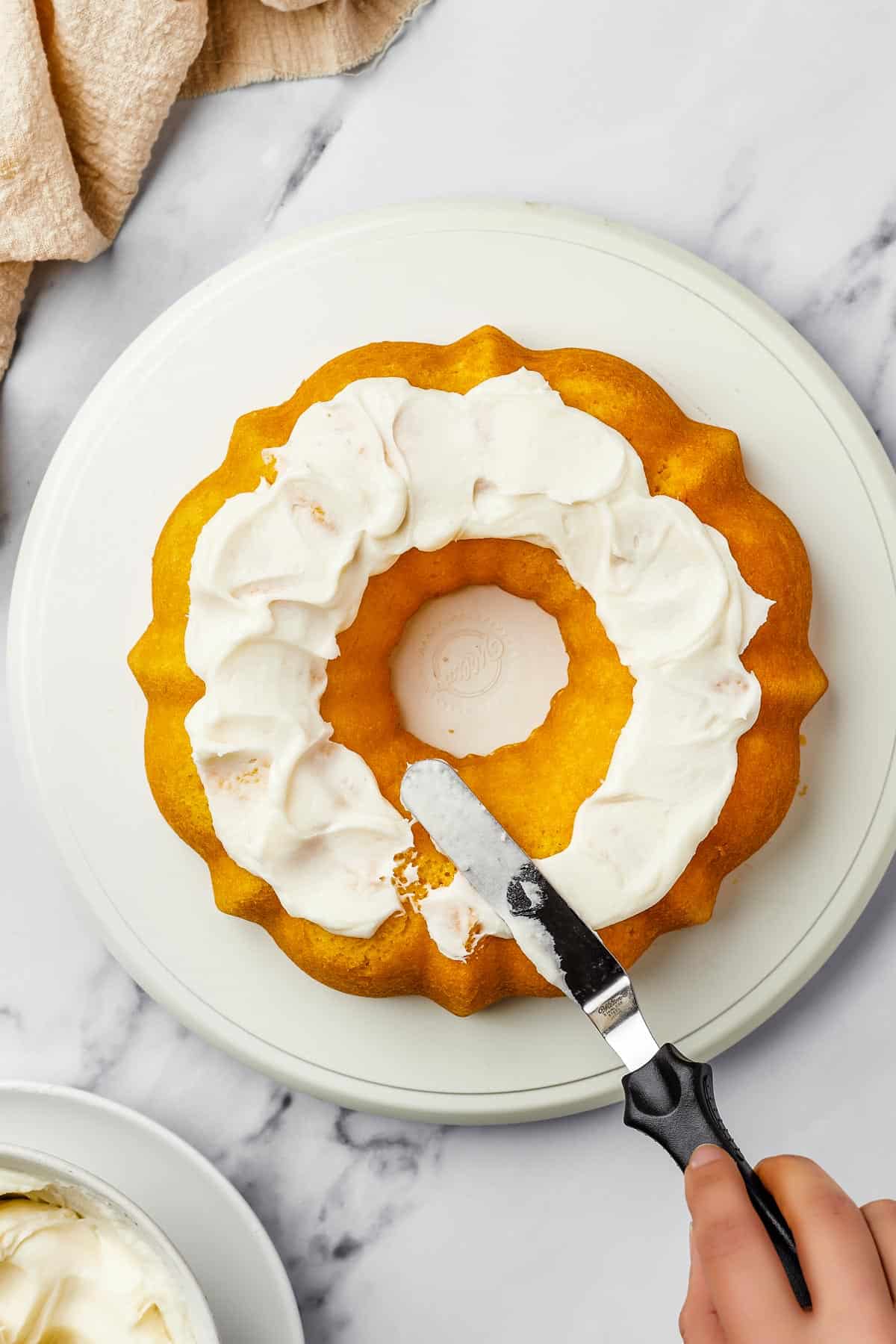 Overhead shot of a bundt cake iced with thick, creamy frosting.