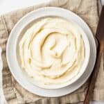 A bowl of creamy white icing on a linen napkin.