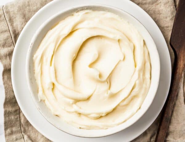 A bowl of creamy white icing on a linen napkin.