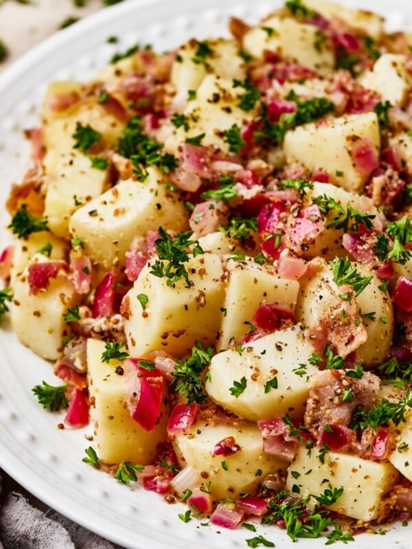 Close-up shot of chopped, boiled potatoes tossed with bacon and dressing.