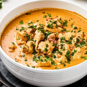 Chicken curry in a white enamel bowl.